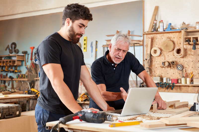 datenschutz-handwerk Ein Schreiner und sein Mitarbeiter schauen in der Werkstatt auf einen Laptop. Datenschutzfür alle Branchen, besonders für das Handwerk.